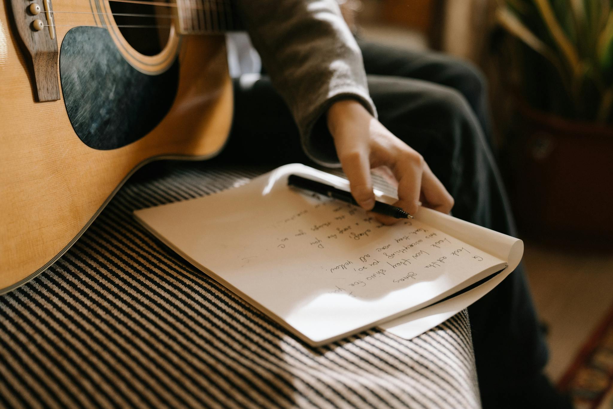 a person writing lyrics with an acoustic